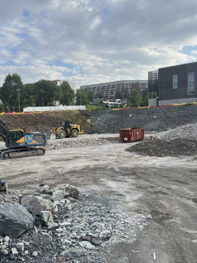 Byggegrop med gravemaskin. Foto.